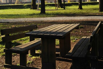 Wooden picnic table with two wooden benches in a park on a sunny day