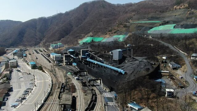 There are old coal mining facilities in Korea and coal piled up like mountains. You can see railways and trains that carry coal.