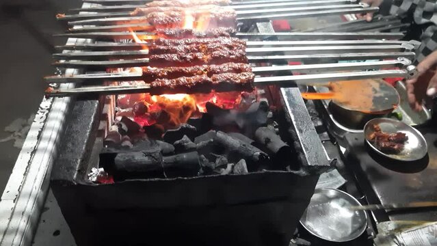 Close up of mutton seekh kabab being amazingly cooked over a coal furnace - Seekh Kabab. Close up of Mutton Seekh Kabab Chicken being barbecued on a charcoal grill Kabab Roll Wale.