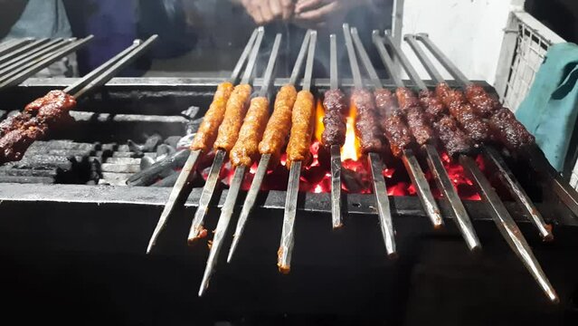 Closeup shot of cooking beef seekh kebab on the griller. shot of cooking seek kebabs on barbecue griller. Barbecuing Marinated beef keema kebabs. Halal Mutton seekh Kebabs on fire.