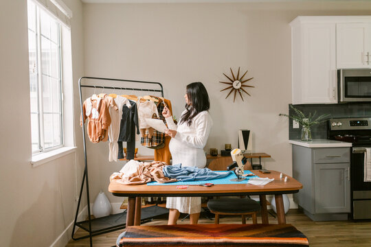 Pregnant business owner reviewing clothes design