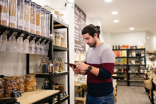 Male employee using tablet in eco friendly shop