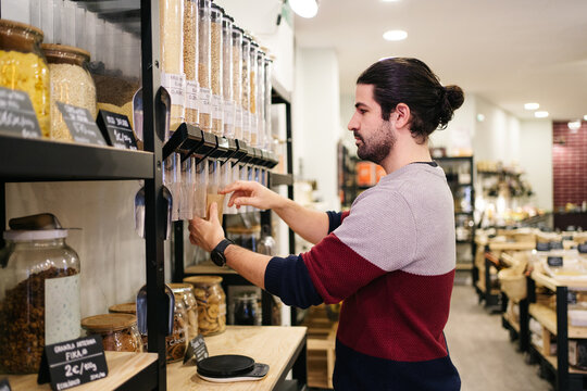 Man packing organic cereal  in eco friendly store