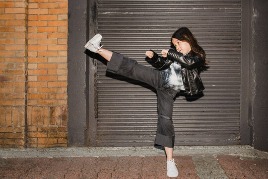 Young girl does a karate kick.