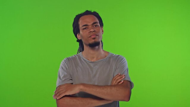 Young disgruntled African American man shows stop gesture and asks to terminate demonstrating disdainful emotions fights against infringement of human rights or segregation stands on chroma key.