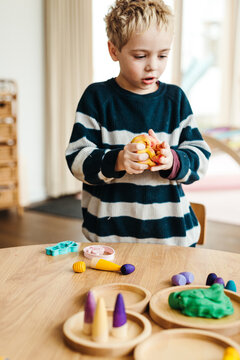 Boy playing with play dough indoors