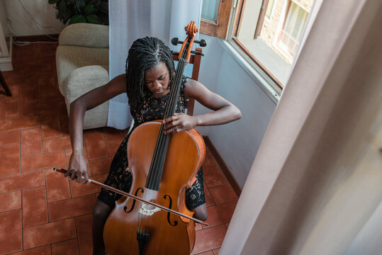 Girl playing cello in a room