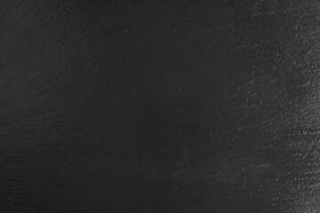 Black slate surface background. Dark grey natural stone texture