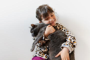 Happy girl holding a cat with love