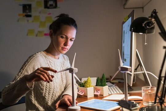 Woman using a windmill model - Powered by Adobe