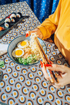 Female eating ramen with chopsticks