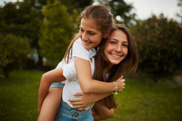 Im her biggest supporter. Cropped portrait of a young girl giving her younger sister a piggyback...