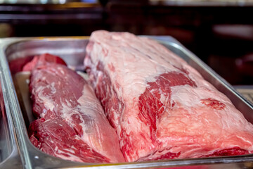 A rib-eye cut of good marbled beef lies in the restaurant, waiting to be cooked