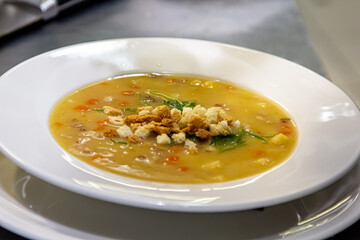 Pea soup with smoked pork and croutons is in the plate