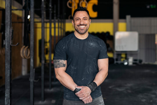 Cheerful sportsman in modern gym