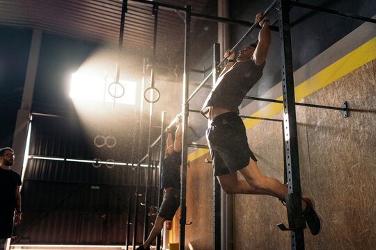 Male athletes doing pull ups in gym