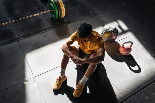 Weightlifter resting on sunlit floor
