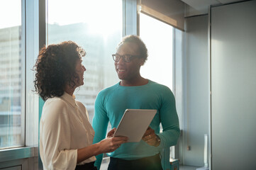 Cheerful diverse couple with tablet