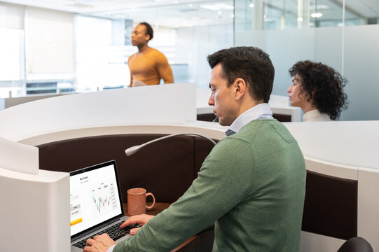 Group of colleagues working on laptop in office