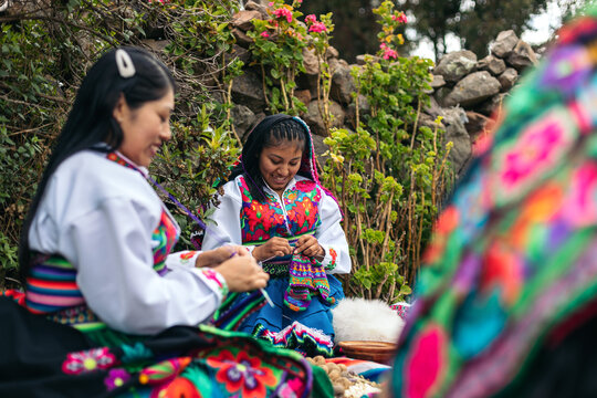 Peruvian women weaving in traditional clothes