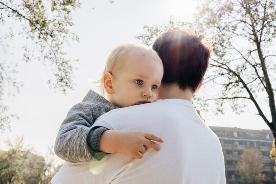 Father carries a two year old child on his shoulder. 