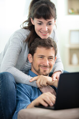 close up of young couple working on laptop at home
