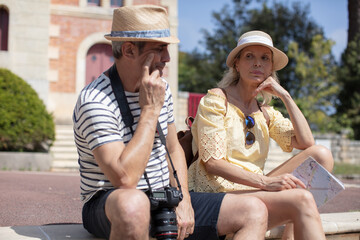 middle aged couple on vacation with map