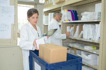 Obraz premium pharmacist holding digital tablet in pharmacy stockroom
