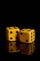 Gambling. Two dice on a black background with reflection