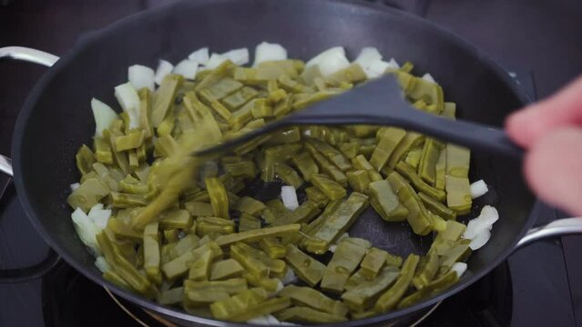 Cactus food being fried with onions by cook. A traditional native Mexican cuisine and street food also known as nopal or nopales. POV shot. 4K.