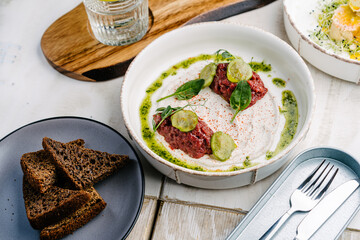 Veal tartar with truffle sauce, pickled cucumber and dark bread