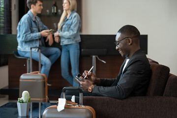 Businessman working on tablet PC while waiting for his flight at airport lounge.