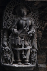 Stone Sculpture of Beautiful Female (Madanikas) with selective focus, 12th century Hindu temple, Ancient stone art and sculptures in each pillars, Chennakeshava Temple, Belur, Karnataka, India.