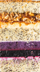 Background texture of cake cut with sponge biscuit, caramel and berry mousse layers. Vertical macro shot