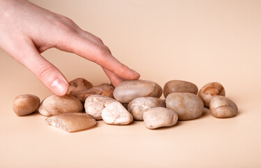 Woman hand touching small stones. Tactile sense and taction concept. Sensation and feelings from contacting smooth solid surface . High quality photo