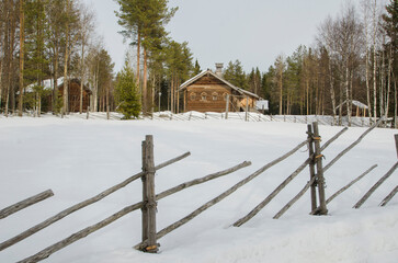 Winter in the Russian village. Wooden fence made of poles