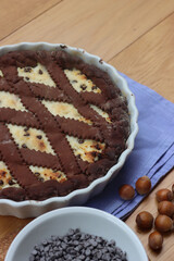 Chocolate shortcrust pastry filled with ricotta cheese and chocolate pieces on wooden table