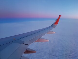 Obraz premium Wing of an airplane in the morning sky