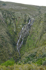 a waterfall, a stream that goes down the mountain, chorro of Los Angeles, Extremadura, Spain. The water falls white from the top of the mountain to the valley, between the cliffs, below the forest awa - obrazy, fototapety, plakaty