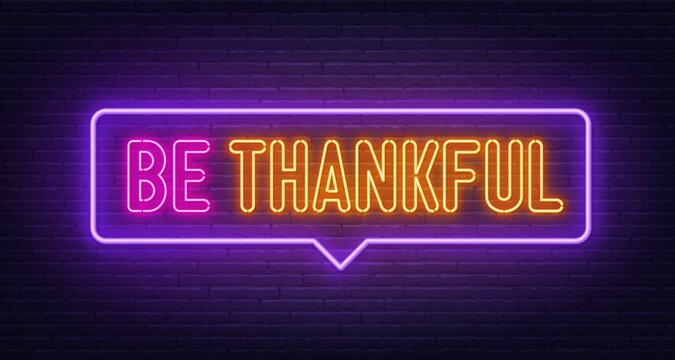 Be Thankful neon sign on brick wall background.