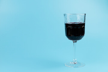 Port wine or fortified red wine  in a glass on blue background. copyspace.