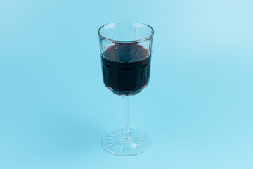 Port wine or fortified red wine  in a glass on blue background. copyspace.