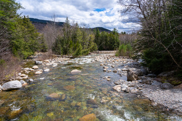 The smooth flow of the Ammonoosuk mountain river among the rocks in the foothills of Mount...
