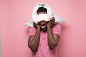 African man shouting aggressively with an angry expression and holding a pillow