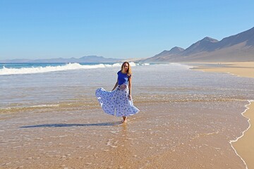 Radosna kobieta na plaży w długiej spódnicy, Fuerteventura
