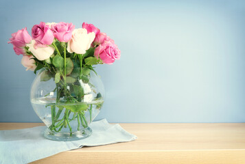 romantic bouquet of pink roses in the vase over wooden table