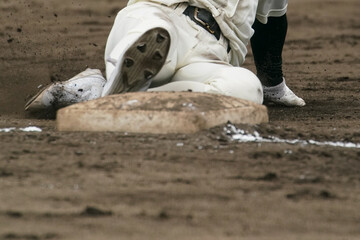 野球の試合中に盗塁を試みてベースに滑り込む野球選手