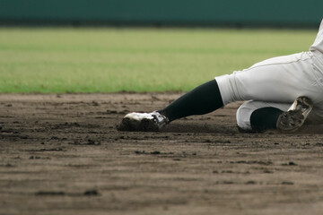 野球の試合中に盗塁を試みてベースに滑り込む野球選手