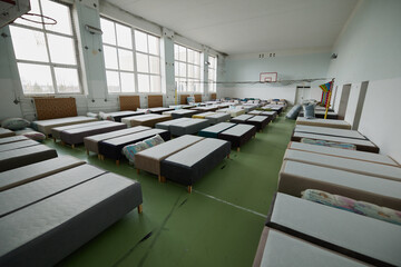 Many multi-colored beds with pillows and linens in the interior of the gym.