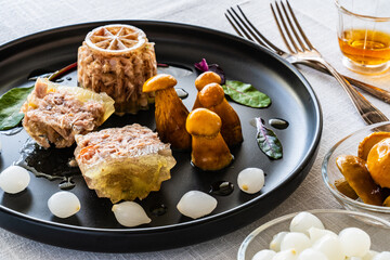 Pork knuckle in jelly and pickled mushrooms on white table
